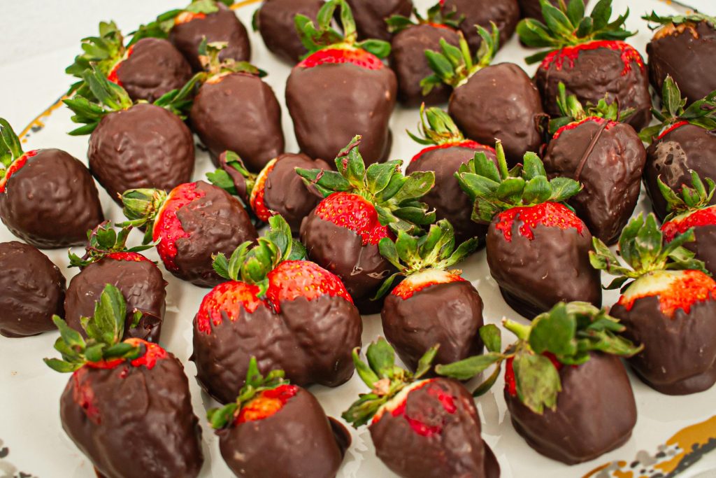 A mouth-watering display of fresh strawberries dipped in rich chocolate, offering a delightful sensory experience.