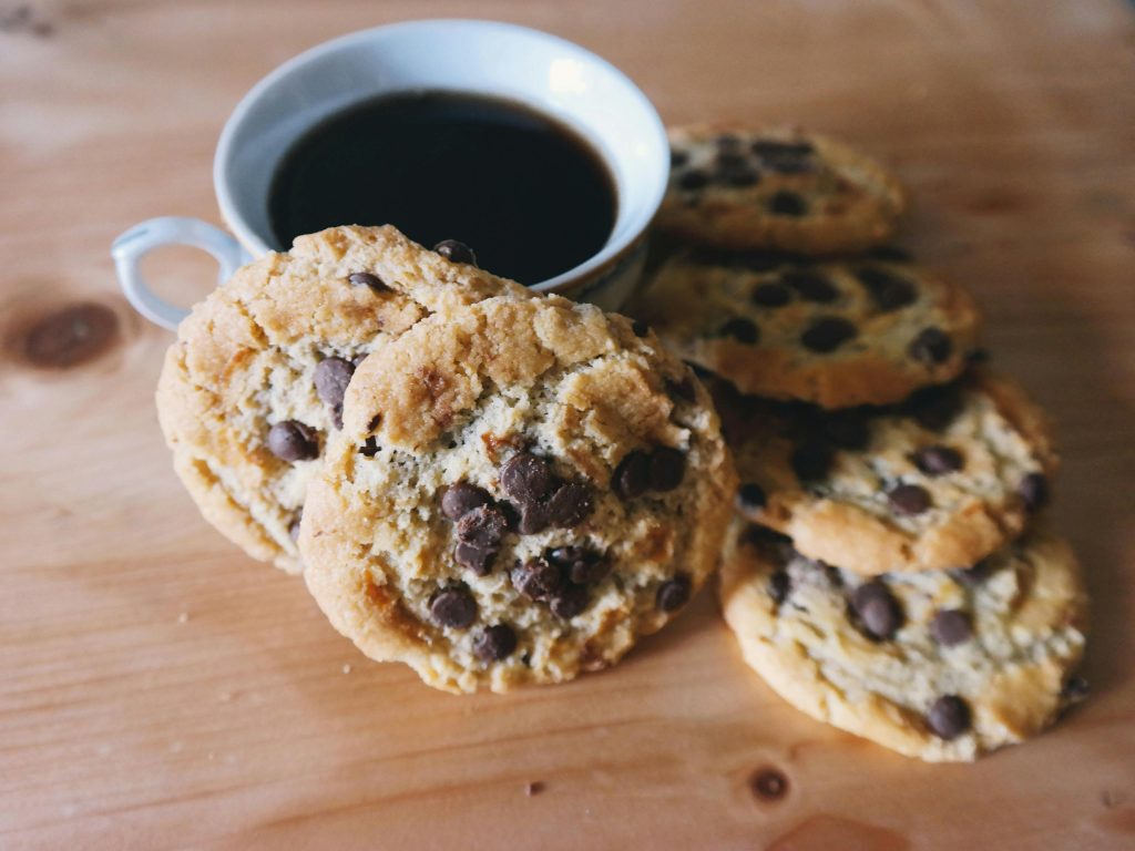 A cozy setup of chocolate chip cookies with a steaming cup of coffee.